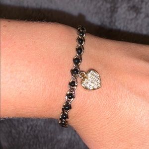 Gold and black bracelet with hanging heart charm